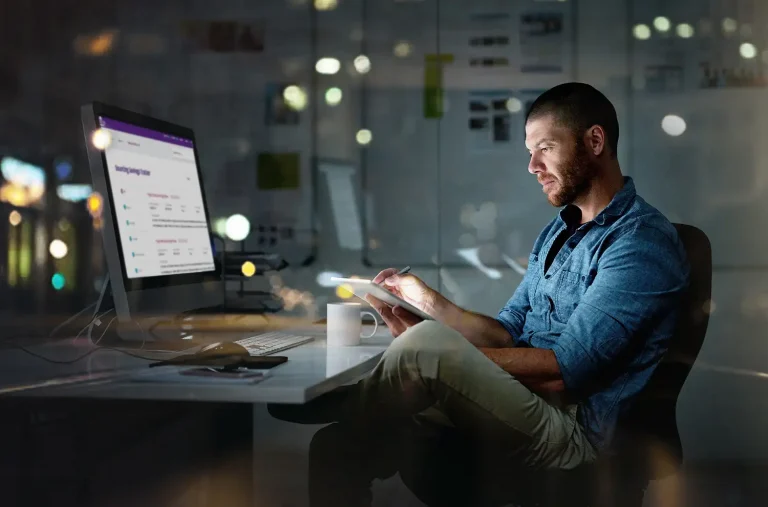 businessman using a computer and digital tablet during a late night at the office