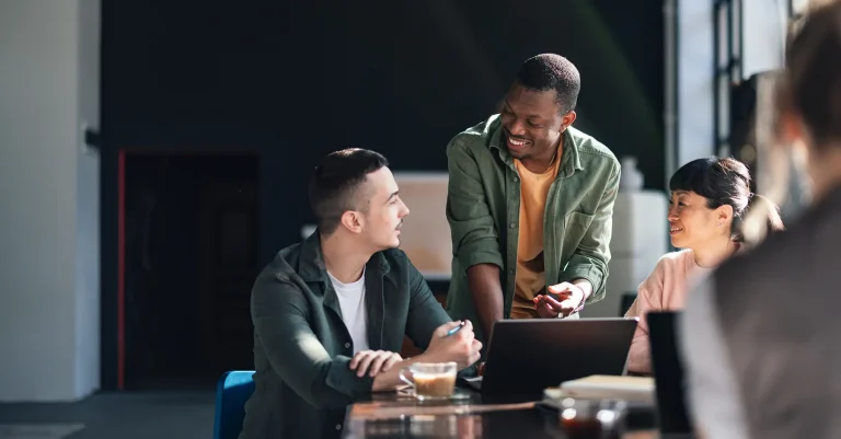 Professionals engaging in a collaborative work session in a sunlit, trendy co-working environment